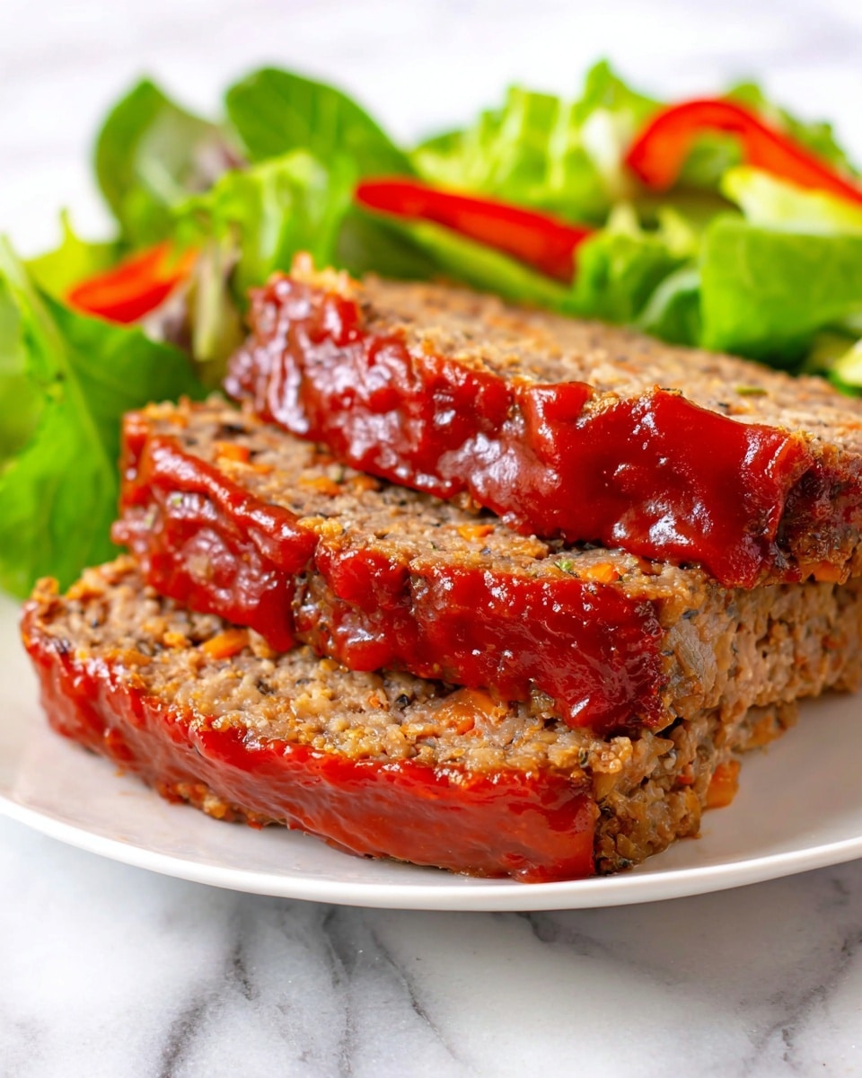 Three thick slices of meatloaf sit stacked on a white plate, each slice showing a coarse, crumbly texture with small bits of vegetables visible inside. The top two slices have a thick, shiny red ketchup glaze covering the edges and top surface, creating a glossy contrast with the matte texture of the meatloaf. In the background, behind the meatloaf, is a fresh green salad with leafy greens and thin slices of red bell pepper, adding vibrant color and freshness to the dish. The plate rests on a white marbled surface. photo taken with an iphone --ar 4:5 --v 7