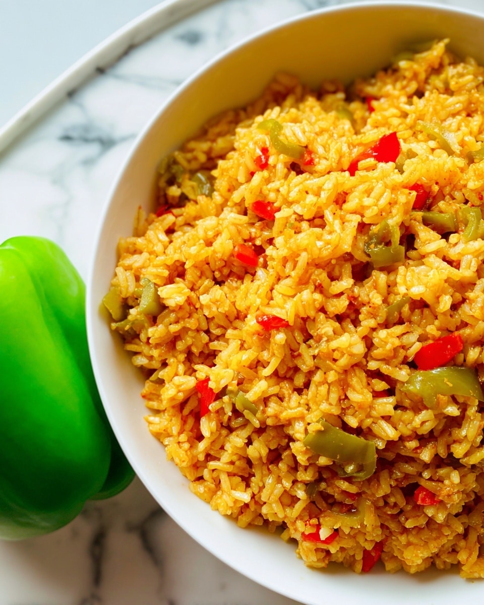 A close-up of a white bowl filled with yellow-orange fried rice mixed with small pieces of red and light green vegetables evenly spread throughout. The texture of the rice looks fluffy with a slightly oily shine, and the grains are distinct. Next to the bowl, there is a bright green bell pepper on a white marbled surface, adding a fresh touch to the scene. The photo is clear, detailed, and brightly lit, capturing the vibrant colors and textures of the dish. photo taken with an iphone --ar 4:5 --v 7