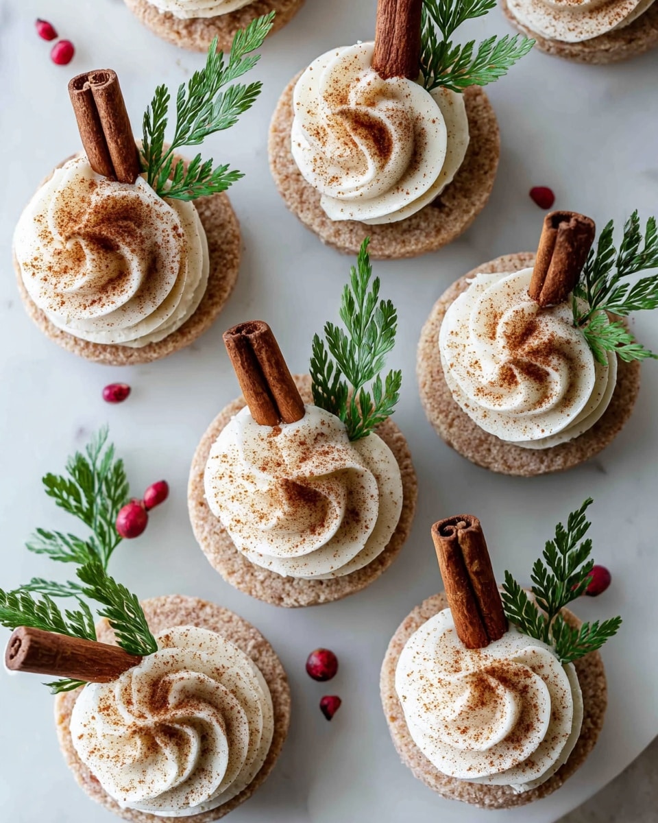 The image shows six round cookies with a rough, beige surface placed on a white marbled background. Each cookie has a swirl of white cream piped on top, dusted lightly with brown cinnamon powder. Sticking vertically from the center of the cream on each cookie is a dark brown cinnamon stick. Next to the cream and cinnamon stick on each cookie is a small sprig of green leaves, adding a fresh touch. Tiny red peppercorns are scattered loosely around the cookies on the surface. The overall look is rustic and festive, with natural colors and textures. Photo taken with an iphone --ar 4:5 --v 7