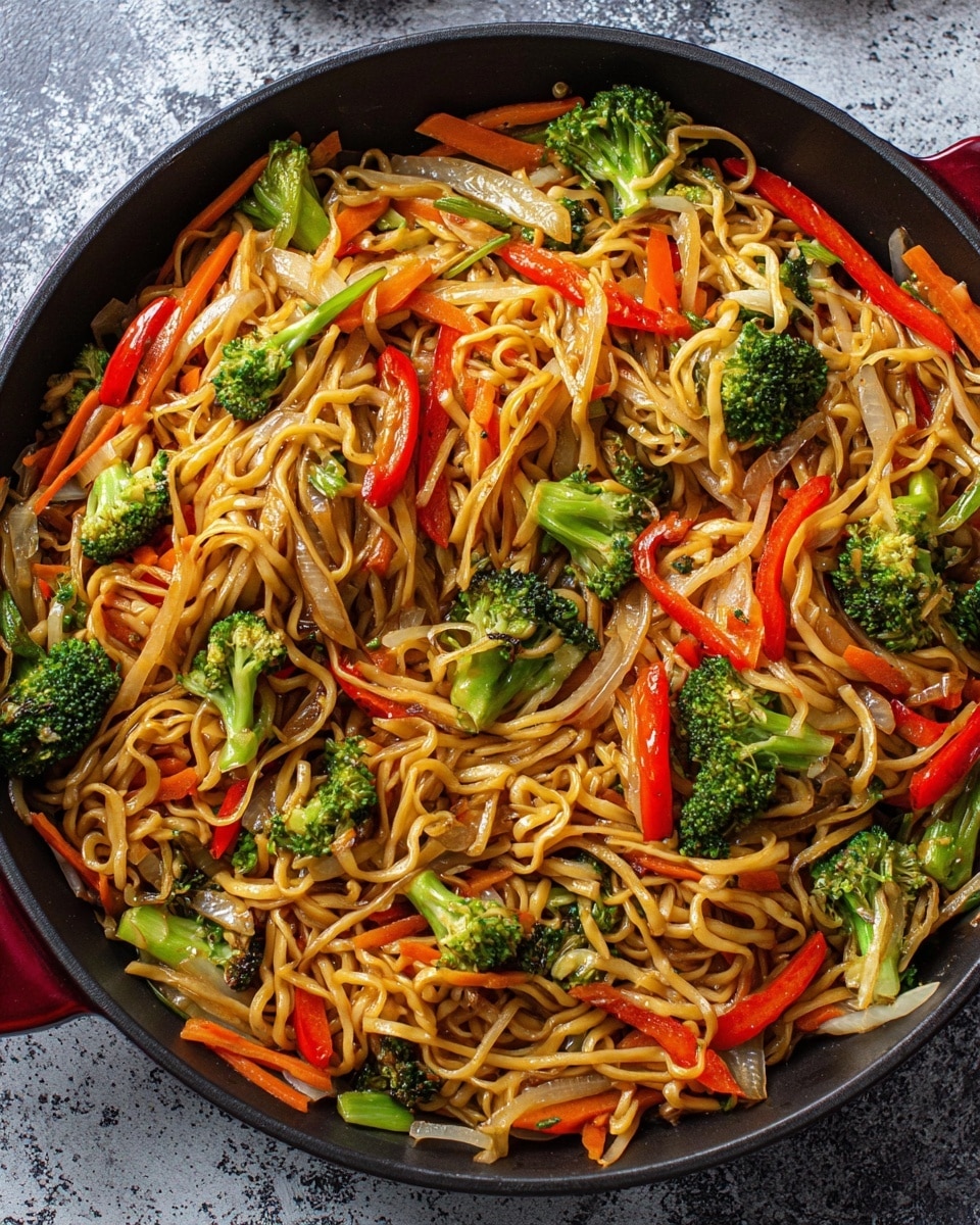 A black pan filled with a colorful mix of noodles and vegetables on a white marbled texture. The bottom layer is light brown stir-fried noodles, soft and twisted, covering the whole pan. Mixed in are bright green broccoli florets, scattered in different parts, with a fresh and slightly crispy texture. Thin strips of vibrant red bell pepper and orange carrots add a crunchy and fresh feel, spread evenly across the noodles. Translucent, cooked slices of onion are mixed throughout, adding a slight shine and softness. The dish looks well-cooked with a shiny light brown sauce coating the noodles and vegetables. photo taken with an iphone --ar 4:5 --v 7