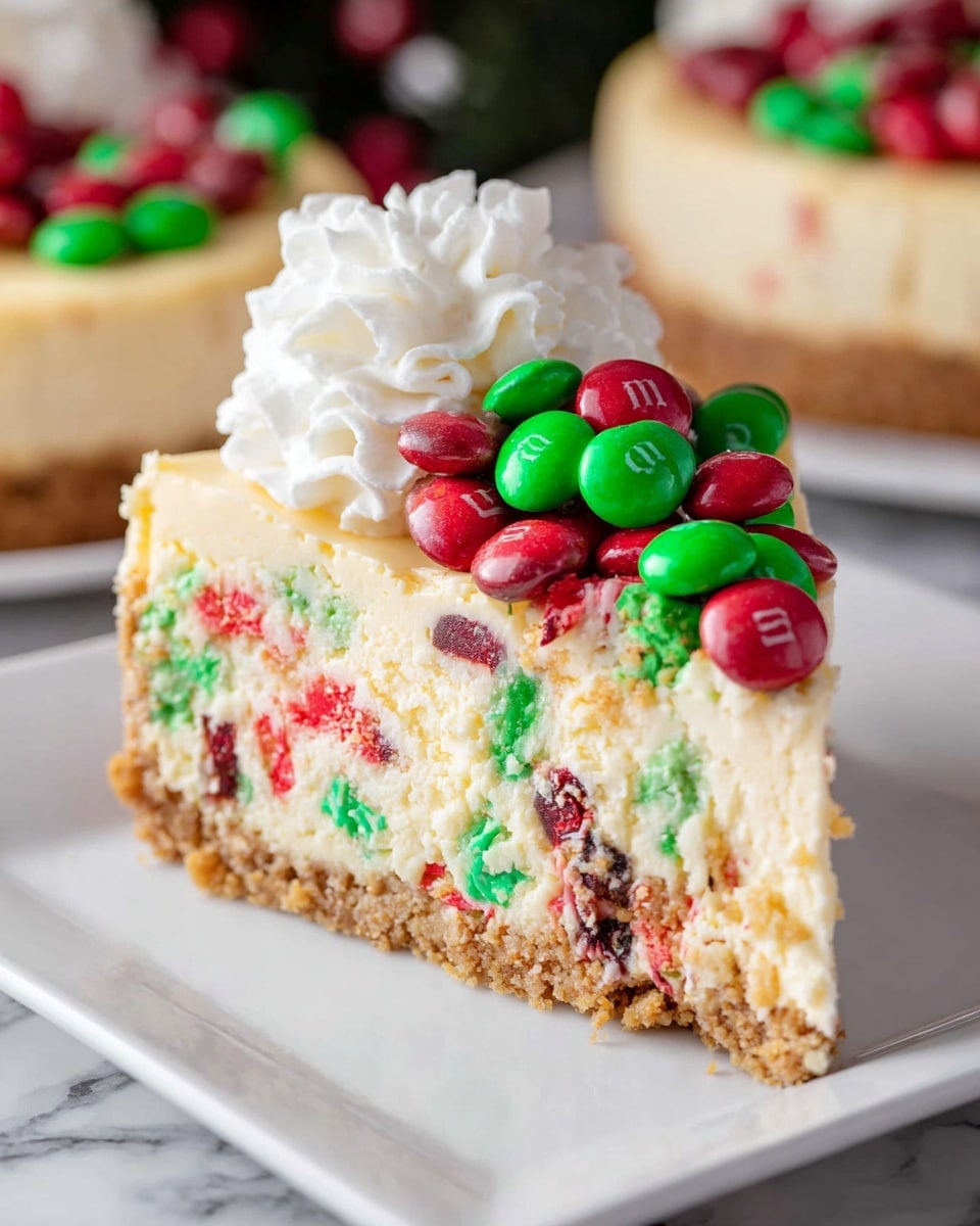 A slice of cheesecake with three visible layers sits on a white square plate on a white marbled surface. The bottom layer is a crumbly golden brown crust. The middle layer is a creamy, light yellow cheesecake filled with red and green candy pieces mixed throughout. The top layer is topped with a mound of white whipped cream on one side and a pile of shiny red and green candies that look like M&Ms on the other side. In the background, there are blurred images of more cheesecakes. photo taken with an iphone --ar 4:5 --v 7