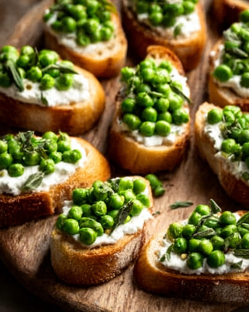 The image shows several small toasted baguette slices arranged closely together on a wooden board, each topped with layers that start with a creamy white spread, followed by a generous pile of bright green peas. The texture of the toasted bread looks crisp and golden brown, contrasting with the soft, smooth cream and fresh, slightly shiny peas. The scene is vibrant with the natural colors of the ingredients standing out against the wood grain background, creating a fresh and appetizing look. photo taken with an iphone --ar 4:5 --v 7