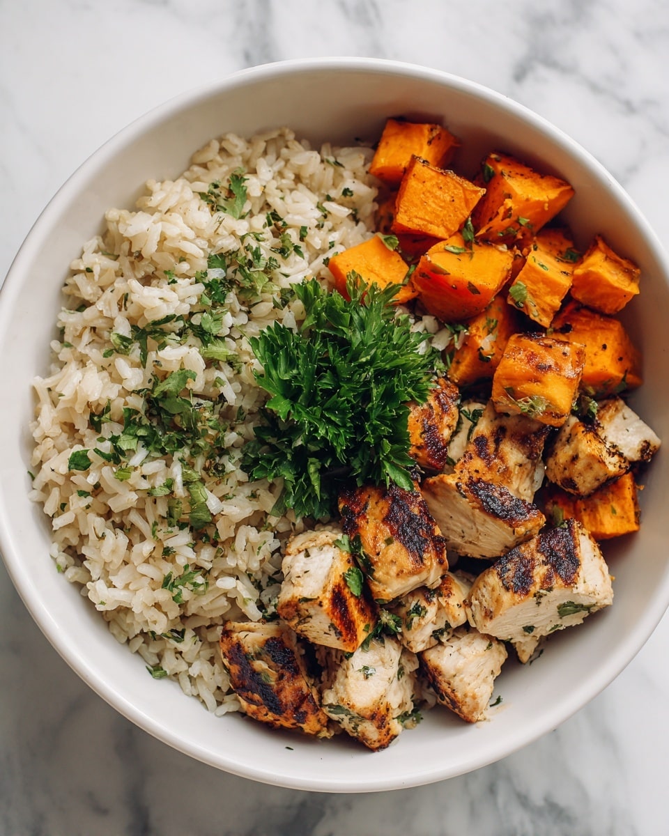 A white bowl filled with creamy, light beige rice sprinkled with green herbs on one side and grilled chicken pieces on the other. The chicken has a slightly charred, golden-brown color with visible grill marks and some green herb flakes on top. Next to the chicken, there are small chunks of roasted orange sweet potatoes. A small bunch of fresh green parsley is placed in the middle, adding a fresh touch. The bowl is set on a white marbled surface. Photo taken with an iphone --ar 4:5 --v 7