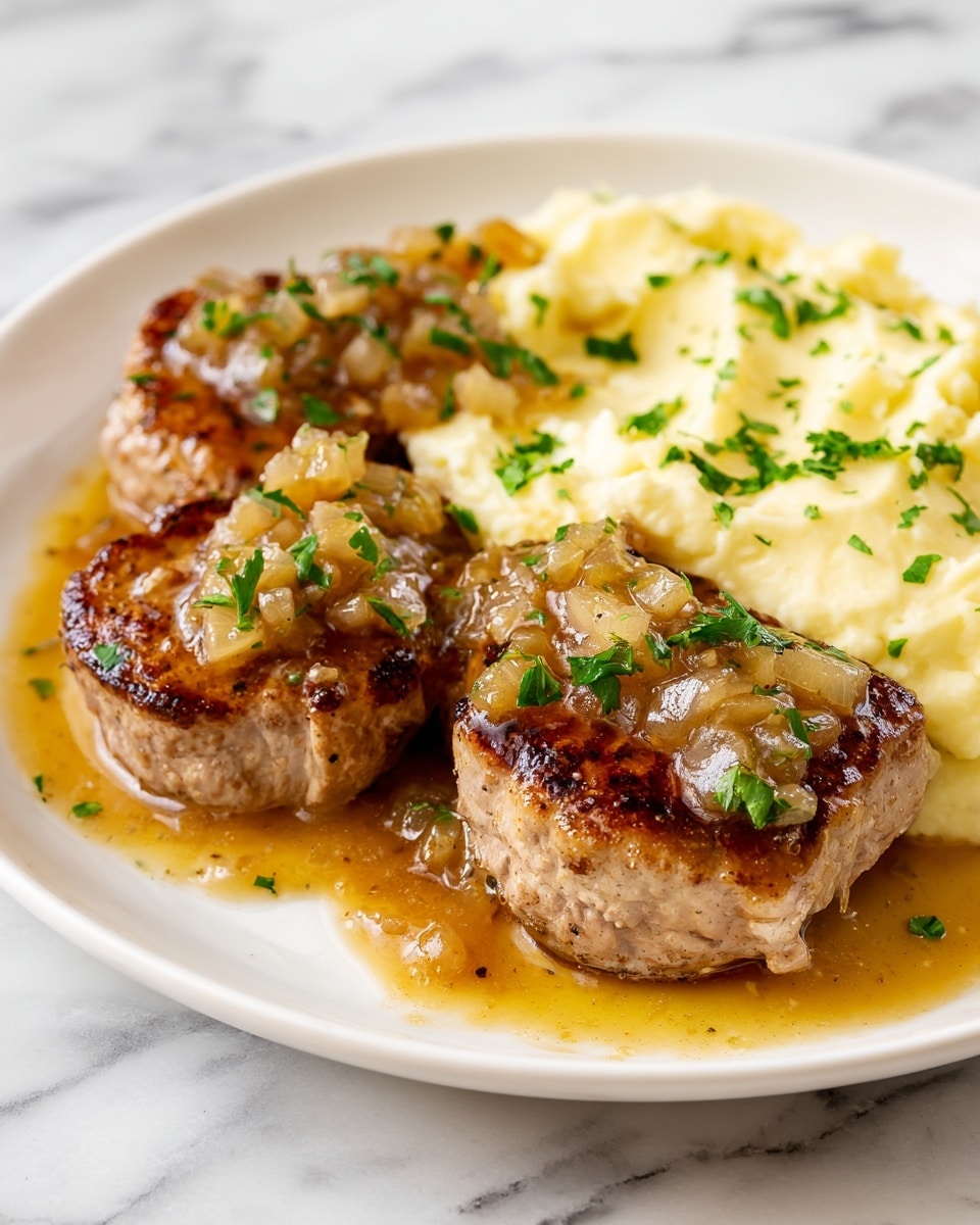 The image shows three thick pieces of pork medallions, browned and juicy, arranged on a white plate. Each pork medallion is topped with a glossy, chunky sauce made of small, light brown apple pieces and fresh green parsley bits. Behind the pork medallions, there is a generous serving of creamy, pale yellow mashed potatoes. Some sauce and chopped parsley are scattered lightly around the edges of the plate. The plate rests on a white marbled surface. photo taken with an iphone --ar 4:5 --v 7