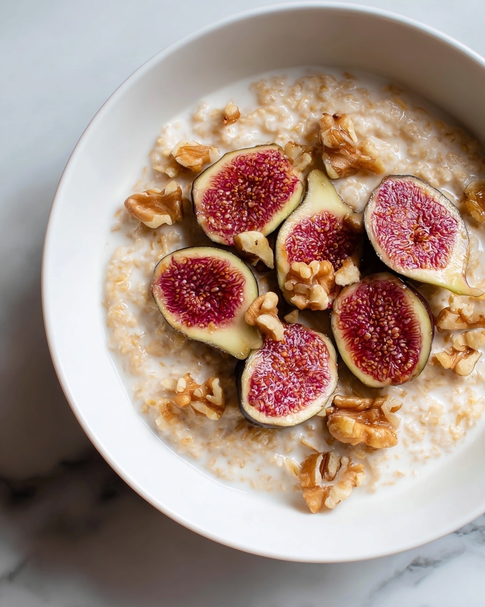 A white bowl filled with creamy oatmeal as the base layer, topped with a generous amount of walnut halves scattered evenly on top, and six halved figs arranged in a circular pattern, showing their deep red, seeded interiors with soft textures. The bowl is placed on a white marbled surface. Photo taken with an iphone --ar 4:5 --v 7