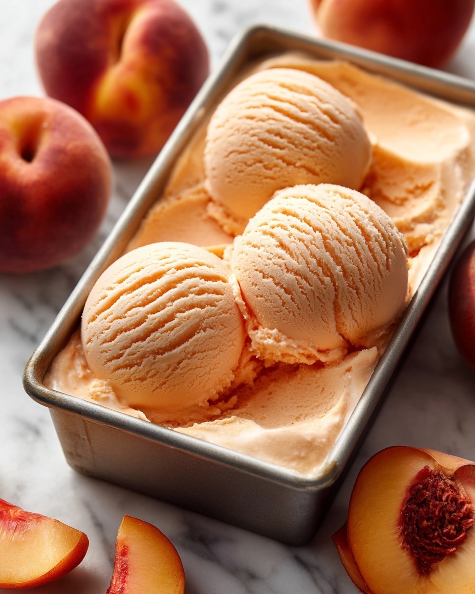 The image shows a loaf cake in a metal baking pan, placed on a wooden board with three whole peaches around it. The cake has a golden brown crust with a rough, slightly cracked surface and a soft, creamy center. On top of the cake, five peach slices are neatly arranged along the middle, showing bright orange and red hues with smooth, shiny textures. The pan and board rest on a white marbled surface, with a light beige cloth partially visible in the background on the upper left side. A wooden spatula is also seen on the right side of the frame. Photo taken with an iphone --ar 4:5 --v 7