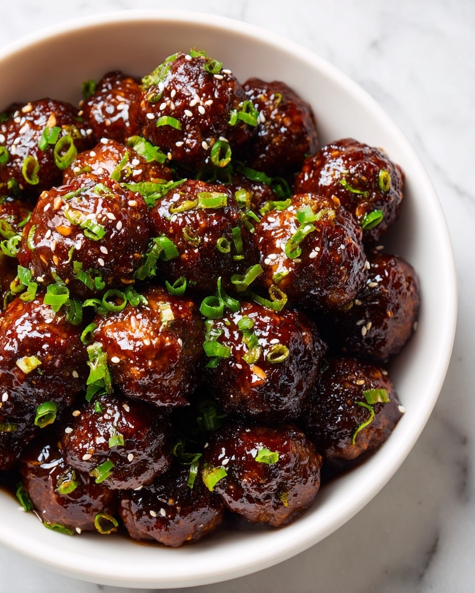 The image shows a close-up of a bowl filled with about two layers of glossy, dark brown meatballs covered in shiny sauce. Each meatball has a textured surface with a caramelized glaze that catches the light. They are topped with bright green chopped scallions scattered evenly and small white sesame seeds sprinkled all over. The bowl is white, round, and deep, with a smooth rim. The background is a white marbled texture. photo taken with an iphone --ar 4:5 --v 7