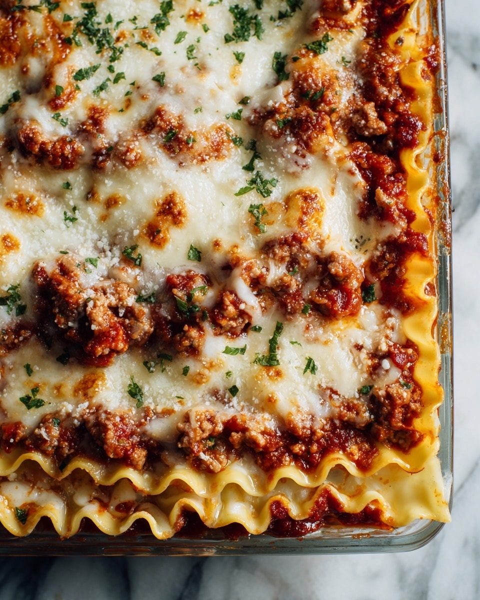 A glass baking dish filled with a baked lasagna that has at least four visible layers: a bottom layer of pale yellow pasta sheets, followed by a thick middle layer of red meat sauce with ground meat, another layer of pasta sheets, and a top layer of melted golden brown cheese with sprinkled green herbs. The edges of the lasagna show the wavy texture of the pasta. The background is softly blurred, and the dish rests on a white marbled surface. photo taken with an iphone --ar 4:5 --v 7