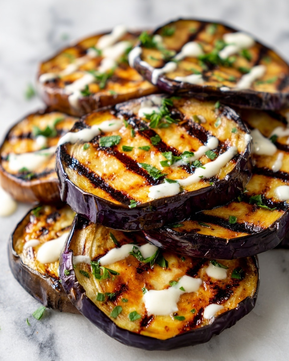 The image shows round slices of grilled eggplant stacked closely together. Each slice has a dark purple outer skin with clear grill marks and a golden brown inside layer that looks soft and moist. The slices are drizzled with white creamy sauce and lightly sprinkled with chopped green herbs. The close-up view highlights the texture of the eggplant and the contrast of colors between the dark skin, light inside, white sauce, and green garnish. The whole scene is on a white marbled texture. photo taken with an iphone --ar 4:5 --v 7