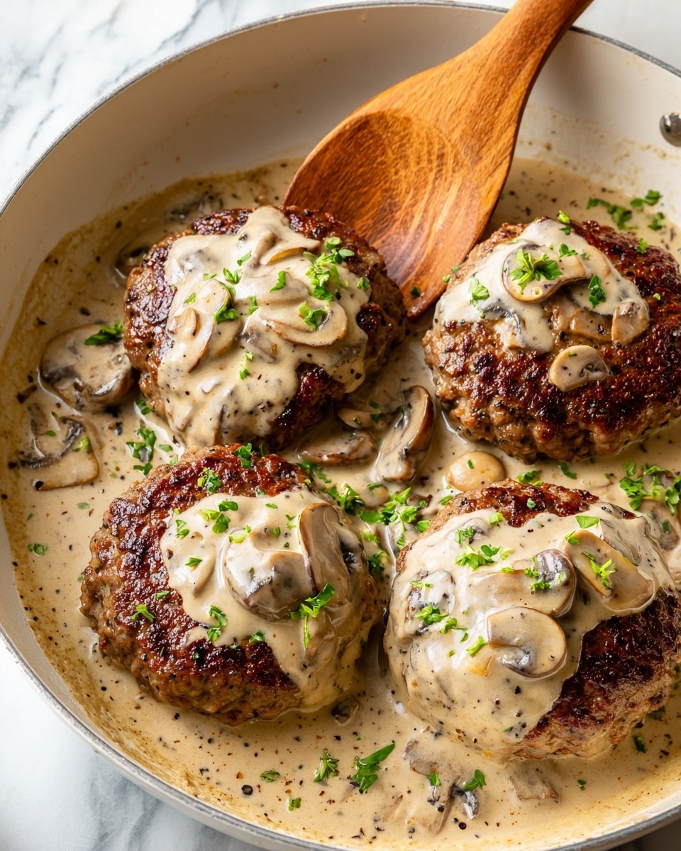 A close-up view of four browned meat patties in a white pan filled with creamy, light beige mushroom sauce that has visible small chunks of mushrooms and herbs. Each patty is topped with a dollop of the sauce, creamy and thick, with a slight glossy texture. The sauce around the patties is speckled with black pepper and chopped green herbs scattered on top, adding a fresh contrast to the beige sauce and brown patties. A wooden spoon is partially dipped into the sauce at the top left corner of the pan. The surface beneath the pan is a white marbled texture. photo taken with an iphone --ar 4:5 --v 7