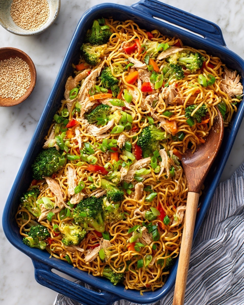 A blue rectangular baking dish is filled with a mix of cooked curly ramen noodles, pieces of cooked chicken, green broccoli florets, thin orange carrot strips, and small red bell pepper chunks, all coated in a savory sauce giving a glossy brownish color to the noodles and chicken. The dish is topped with bright green chopped scallions scattered evenly across the surface. A wooden spoon is scooping some of the noodles and vegetables inside the dish. The dish sits on a white marbled surface with a white and green striped cloth napkin next to it, along with a small white bowl containing sesame seeds nearby. photo taken with an iphone --ar 4:5 --v 7