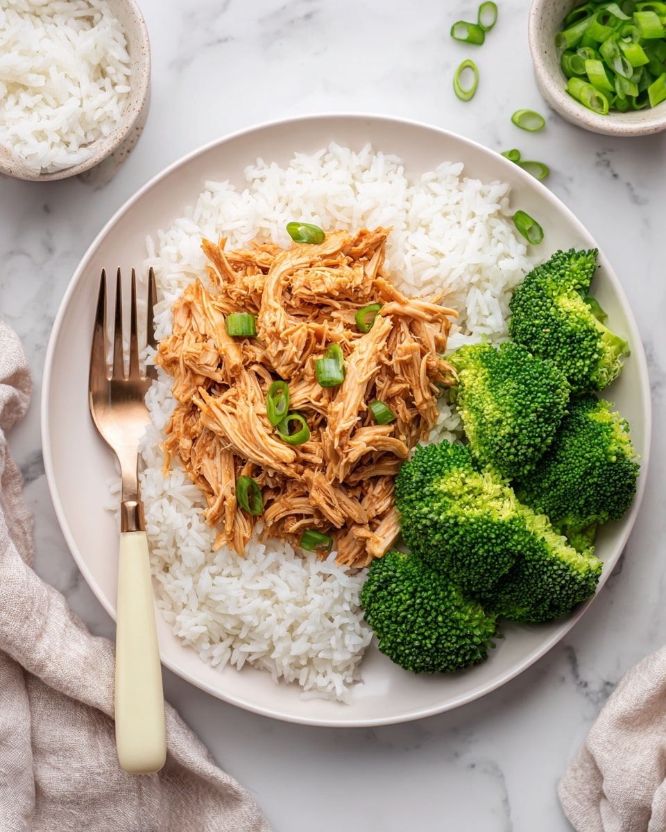 A white plate holds three main layers: the bottom layer is fluffy white rice spread evenly, the middle layer shows shredded chicken with a glossy, light brown sauce covering the rice in the center, and the top layer consists of green sliced scallions scattered over the chicken. On the right side of the plate are bright green steamed broccoli florets arranged neatly. A fork with a light cream handle rests on the left edge of the plate. The plate sits on a white marbled surface with small bowls and cloth napkin edges visible around the scene, creating a fresh and clean look. Photo taken with an iphone --ar 4:5 --v 7