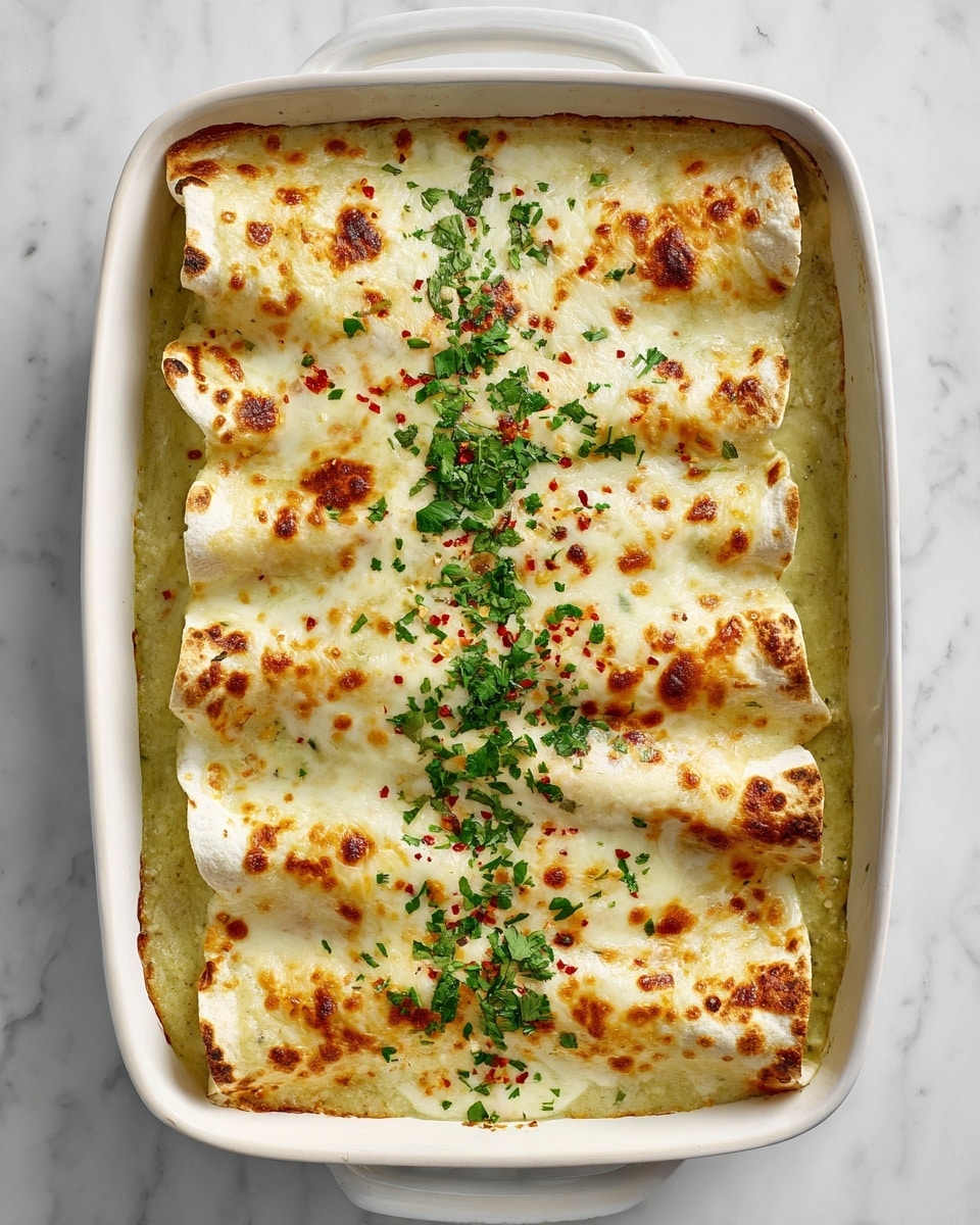 A white baking dish filled with four large rolled enchiladas covered in a thick, creamy, light green sauce. The top layer is melted white cheese, browned in spots with crispy edges, sprinkled with small red chili flakes. A bright green chopped cilantro garnish runs down the middle lengthwise. The enchiladas' edges are golden brown and slightly crispy, peeking out beneath the cheese. The dish sits on a white marbled surface. photo taken with an iphone --ar 4:5 --v 7